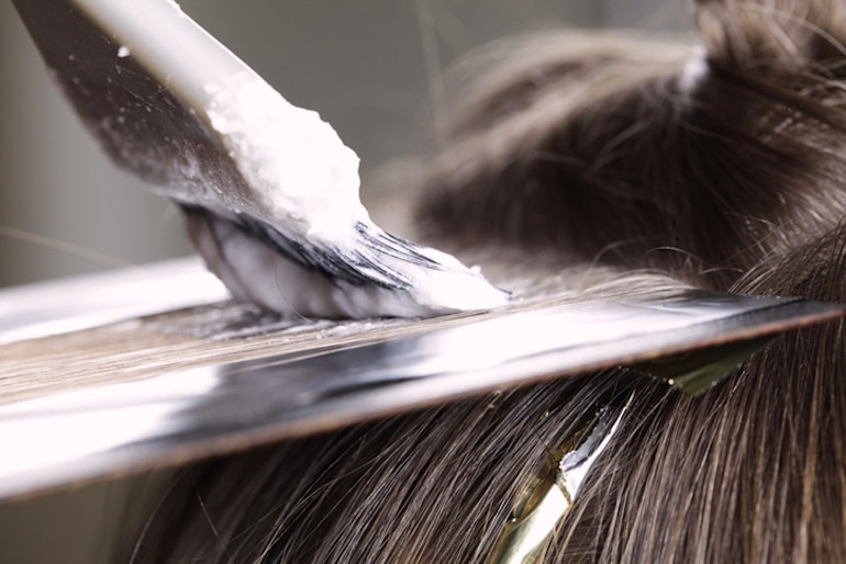 女人的头发被挑亮了;化学物质会导致头发损伤和断裂