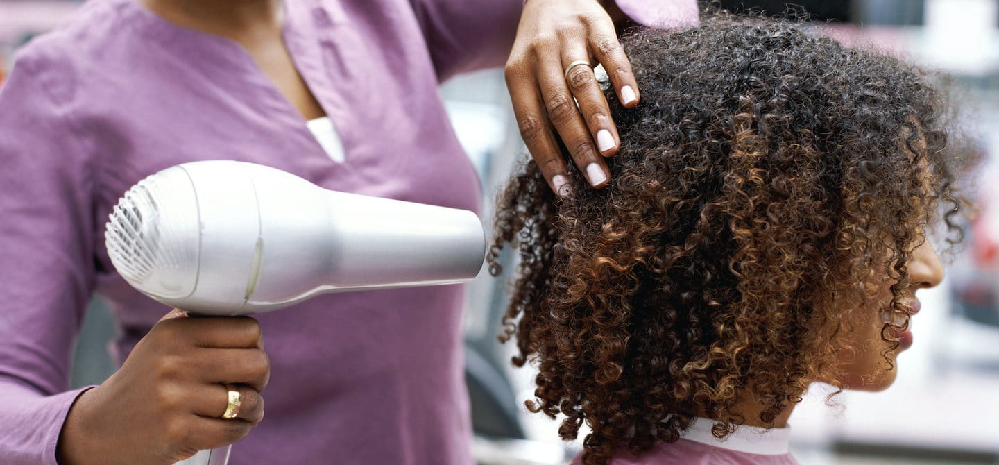 一位黑人妇女在沙龙里晒她自然的头发