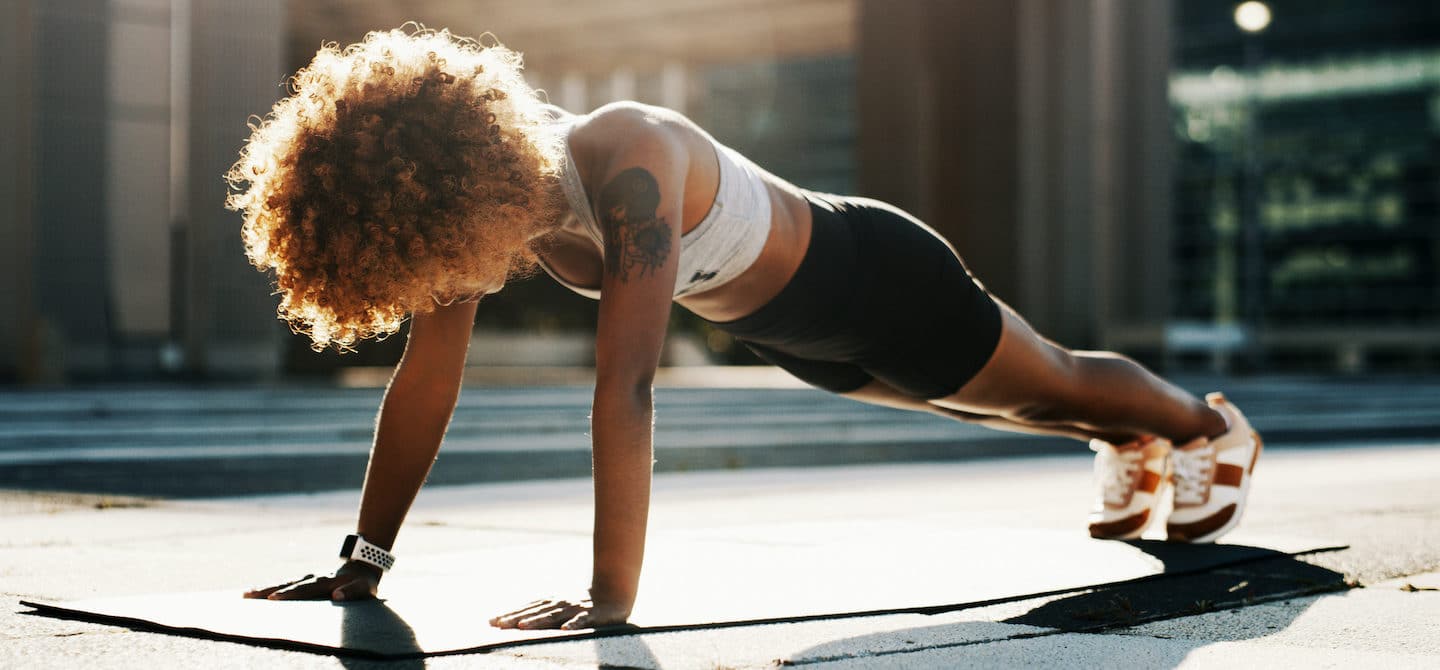 女性以平板姿势在户外锻炼以增强她的免疫系统