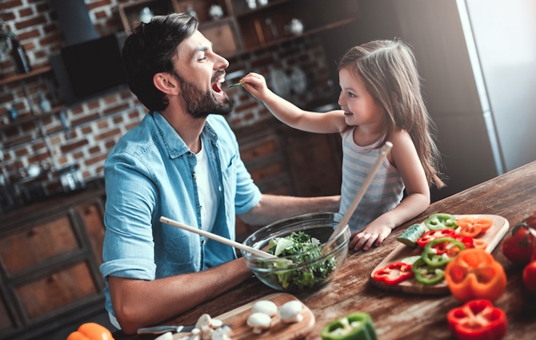 女儿喂她爸爸吃蔬菜来说明为什么我们应该好好咀嚼食物
