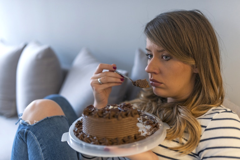 一个伤心的女人独自吃蛋糕