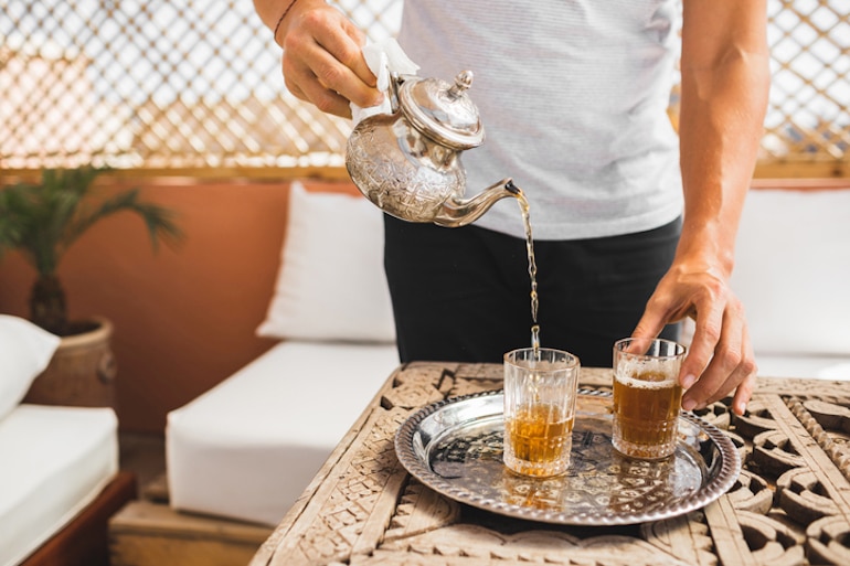 一名男子正在倒摩洛哥茶，以帮助他满足一天的补水配额