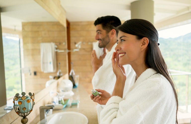 夫妇在浴室做他们的早晨护肤例行，其中包括最好的烟酰胺产品的皮肤