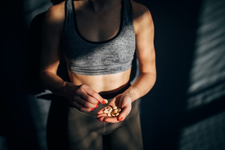 妇女吃坚果作为锻炼后的健康食物