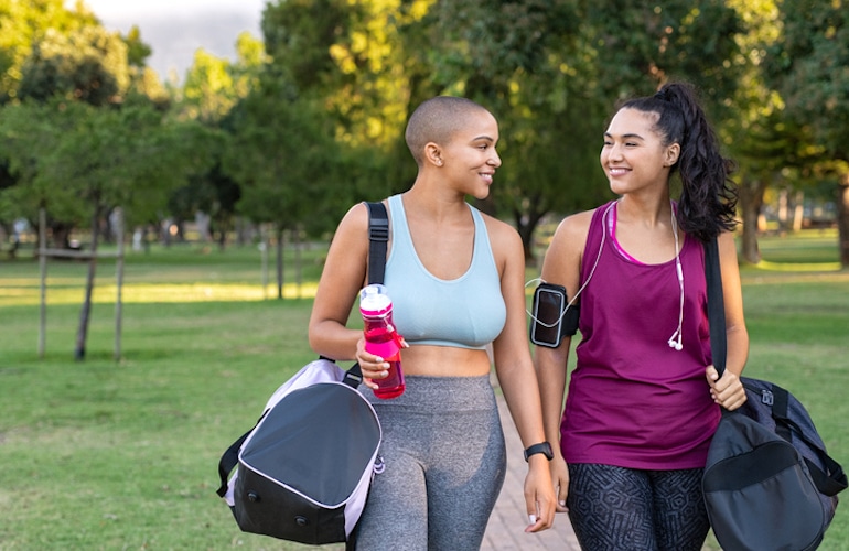 两个女性朋友在公园散步光锻炼来帮助阻止自然痛经