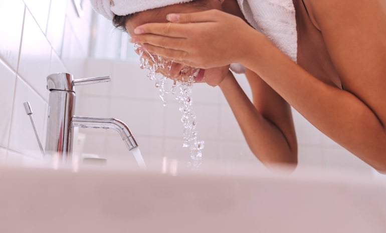 妇女用洗面奶洗脸，以去除多余的皮脂、汗水和化妆品