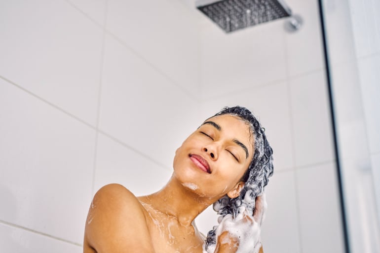 女人在淋浴头过滤器下洗头